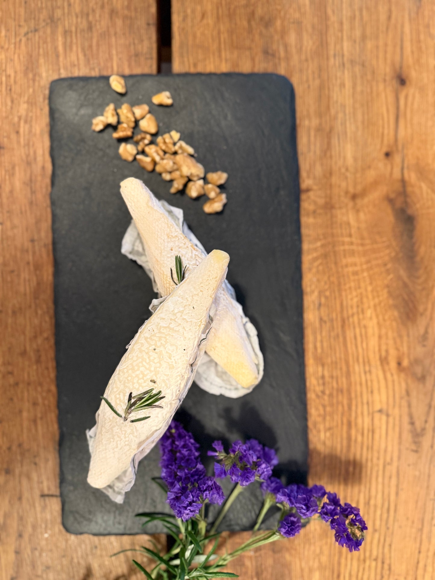La Bouyguette Ziegen-Weichkäse aus Rohmilch mit Rosmarin und Walnüssen auf Schiefer — französischer Käse aus dem Tarn